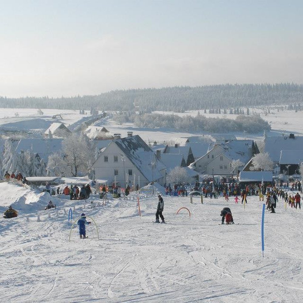Hohenbogenbahn in Germany - a group of people skiing down a snow covered hill.