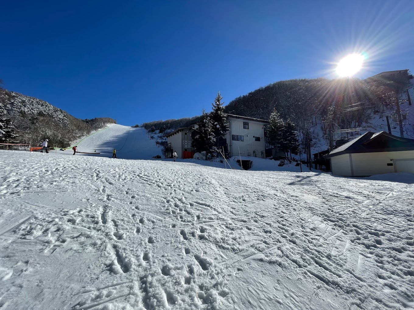 Giant Ski area in Japan - a snow covered ski slope with a house in the background.