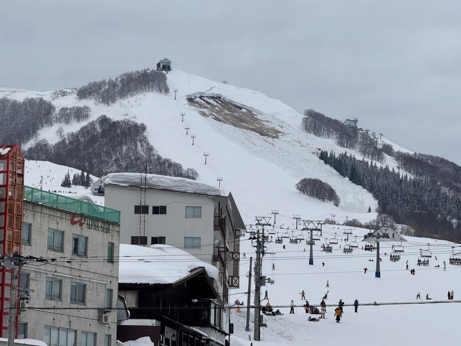 Giant Ski area in Japan - a ski lift going up a snowy hill.