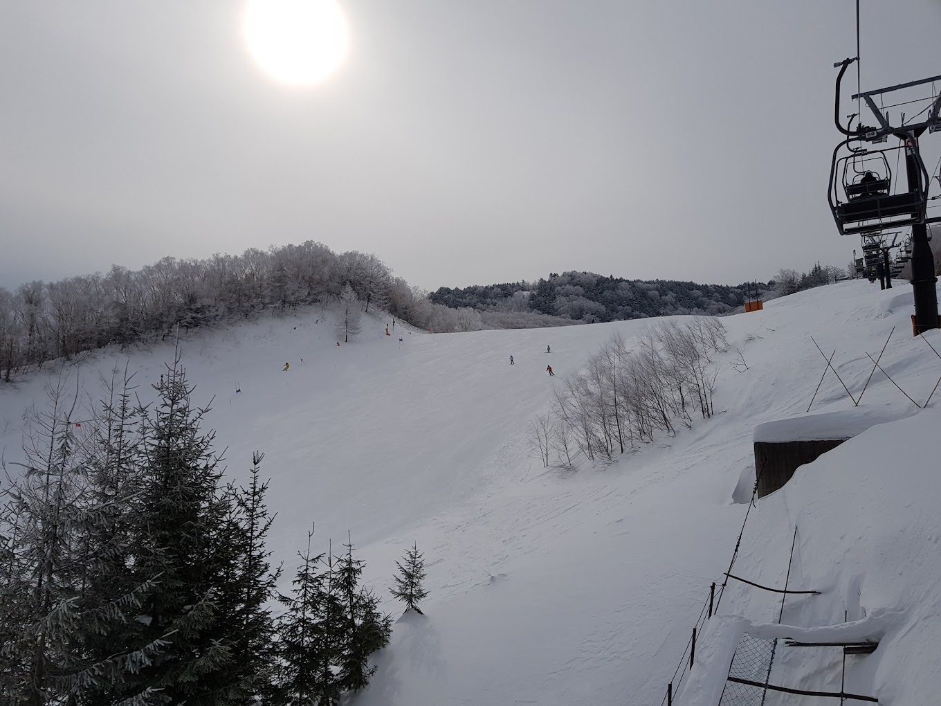 Giant Ski area in Japan - a ski lift going down a snowy slope.