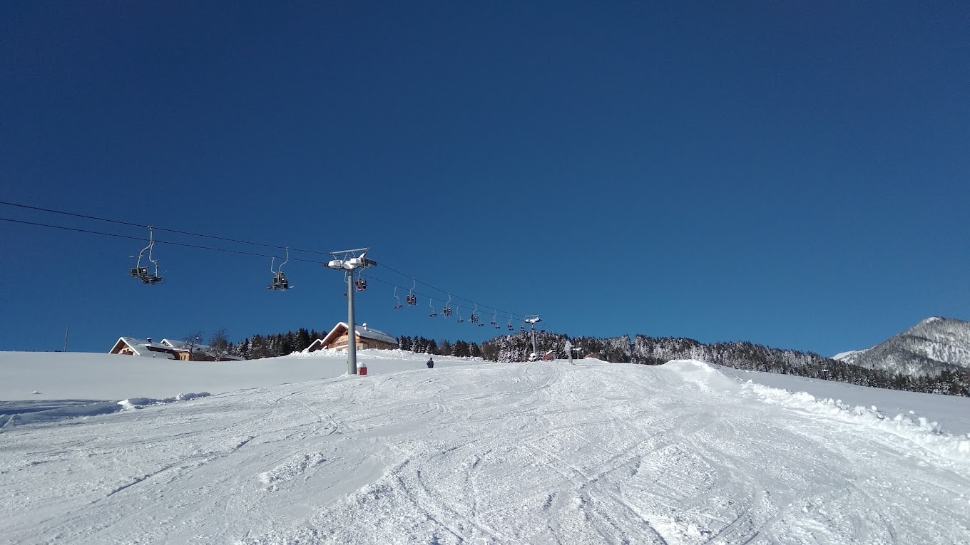 Kötschach-Mauthen in Austria - a person on a snowboard going down a hill.
