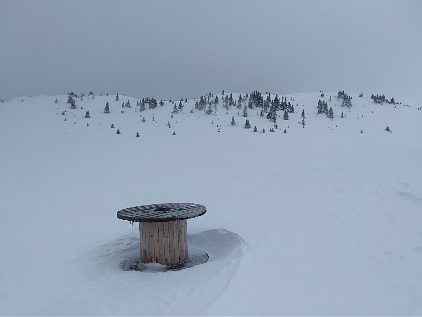 Radusa in Bosnia and Herzegovina - a bench in the snow with trees in the background.
