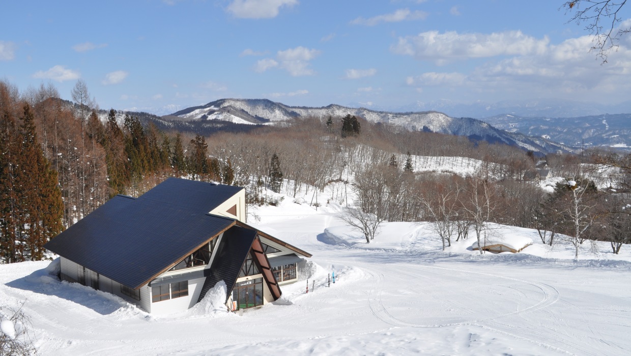 Asahi Shizen in Japan - a house in the snow with mountains in the background.