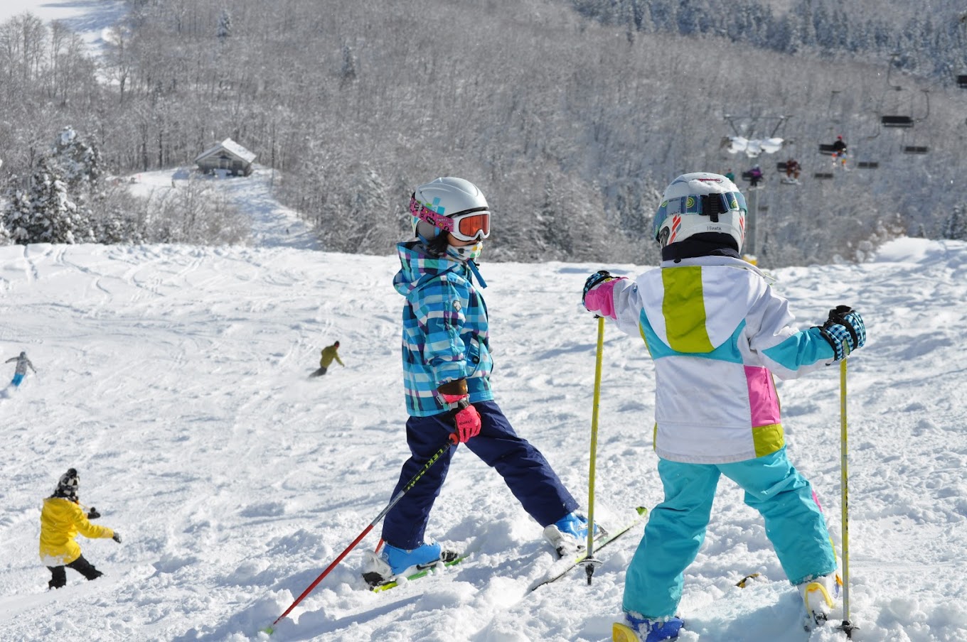 Asahi Shizen in Japan - a group of children skiing down a snowy slope.