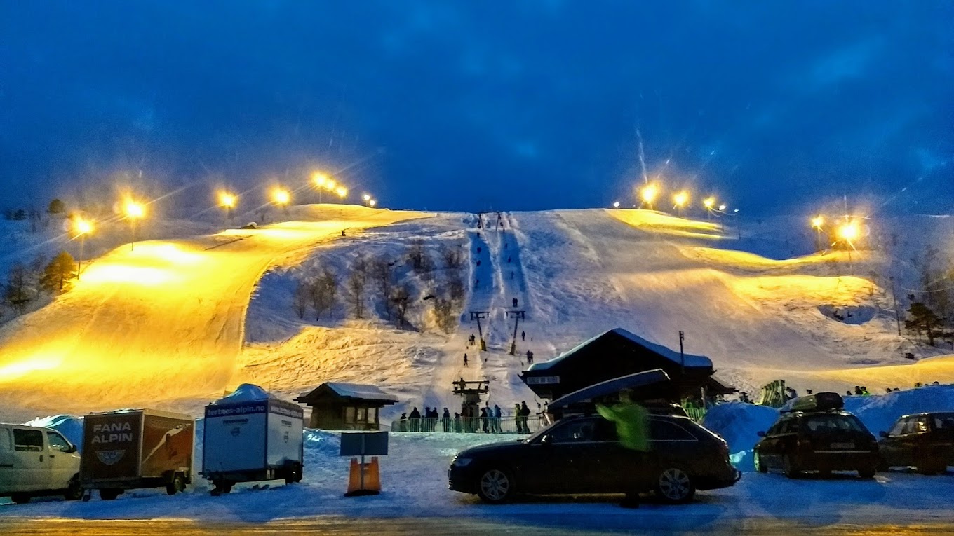 Eikedalen in Norway - a group of vehicles parked in front of a mountain.