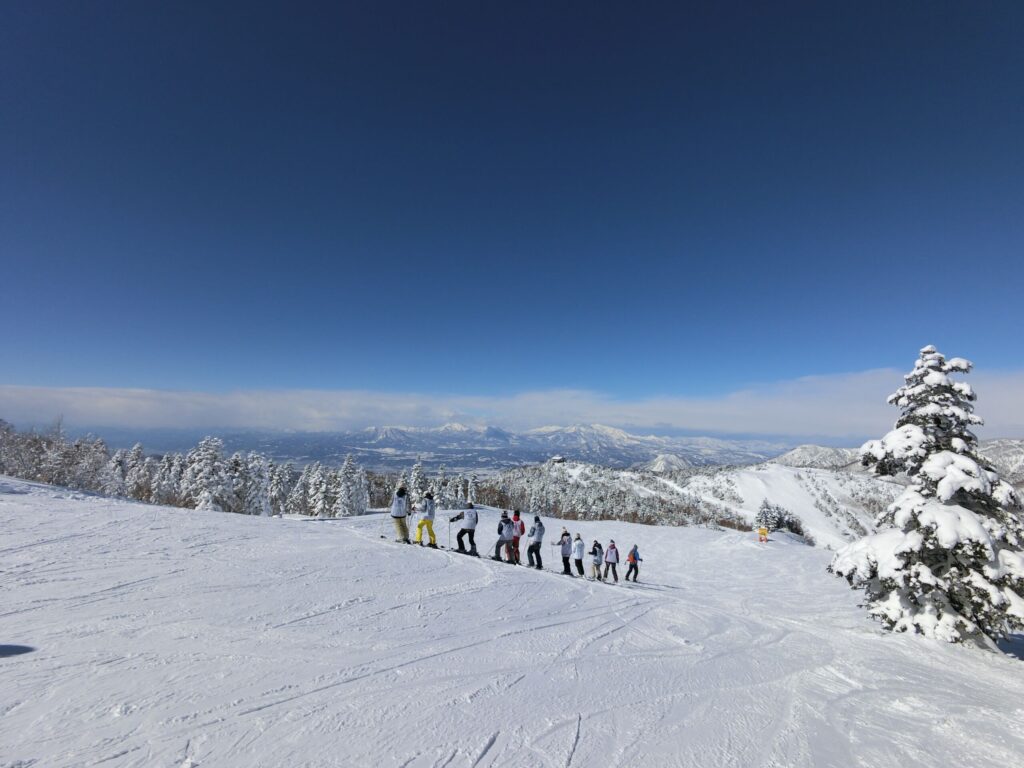 Shiga Kogen Terakoya in Japan - a group of people standing on top of a snow covered mountain.