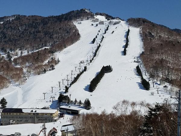 Shiga Kogen Terakoya in Japan - a snow covered mountain with a ski lift in the background.