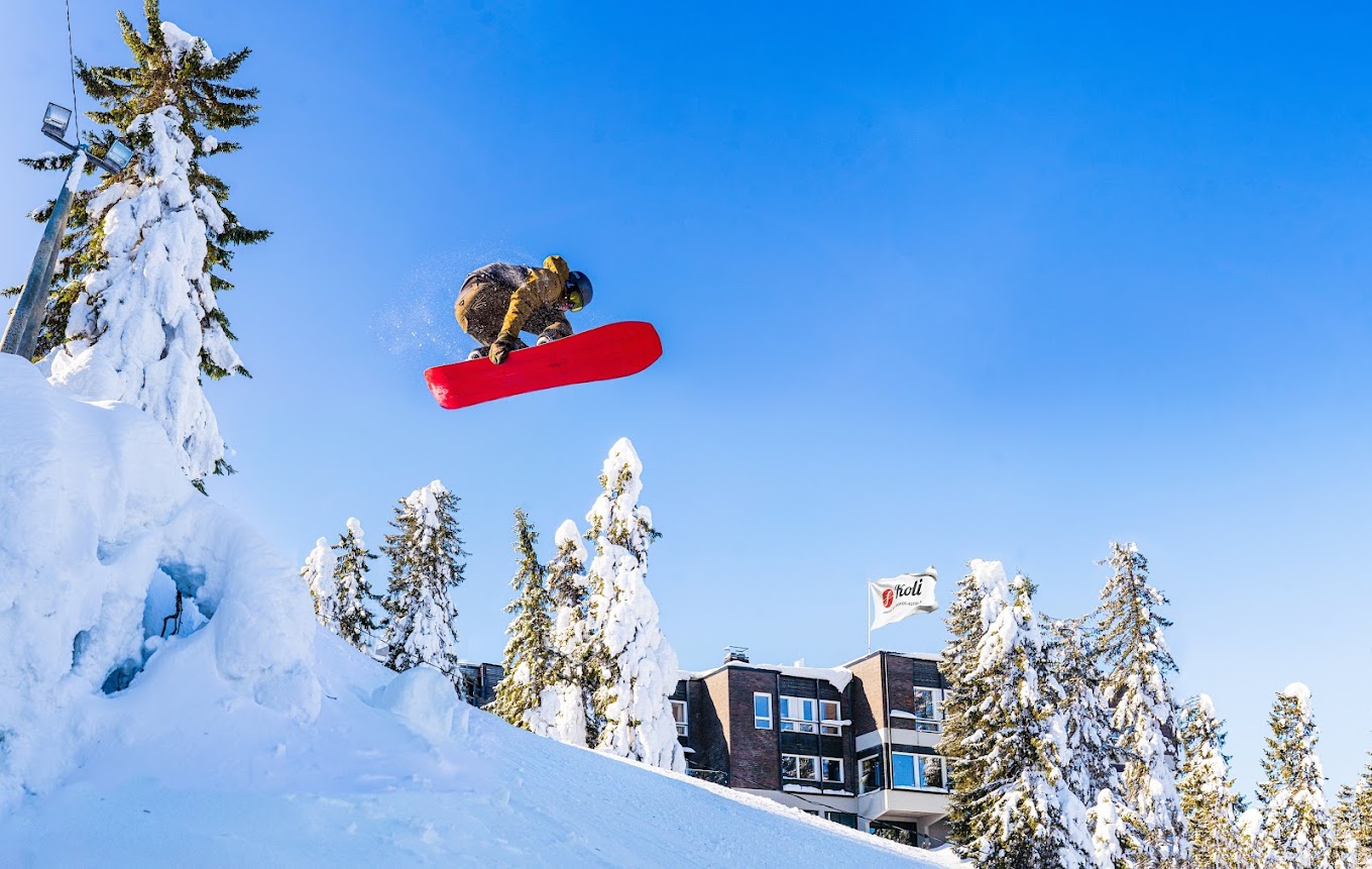 Koli Ski - Ukko-Kolin rinteet in Finland - a man flying through the air while riding a snowboard.
