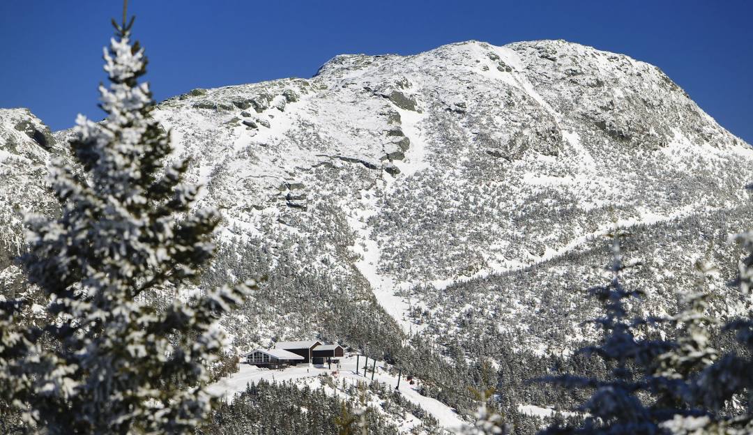 Stowe in USA - a snow covered mountain with trees in the fore.