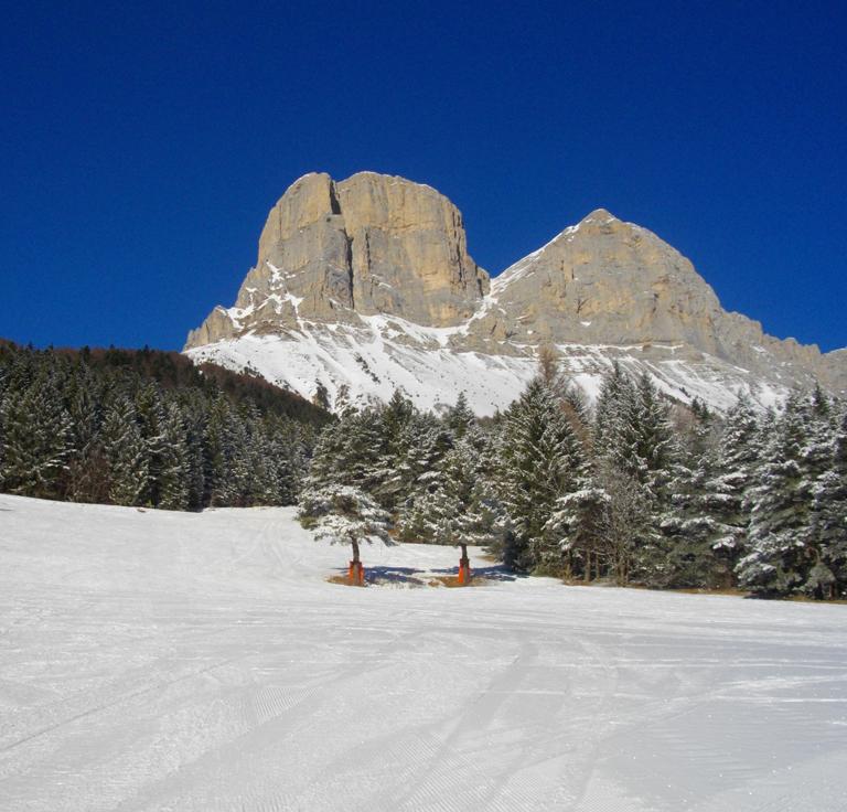 Col de l'Arzelier in France - a person skiing down a snow covered mountain.