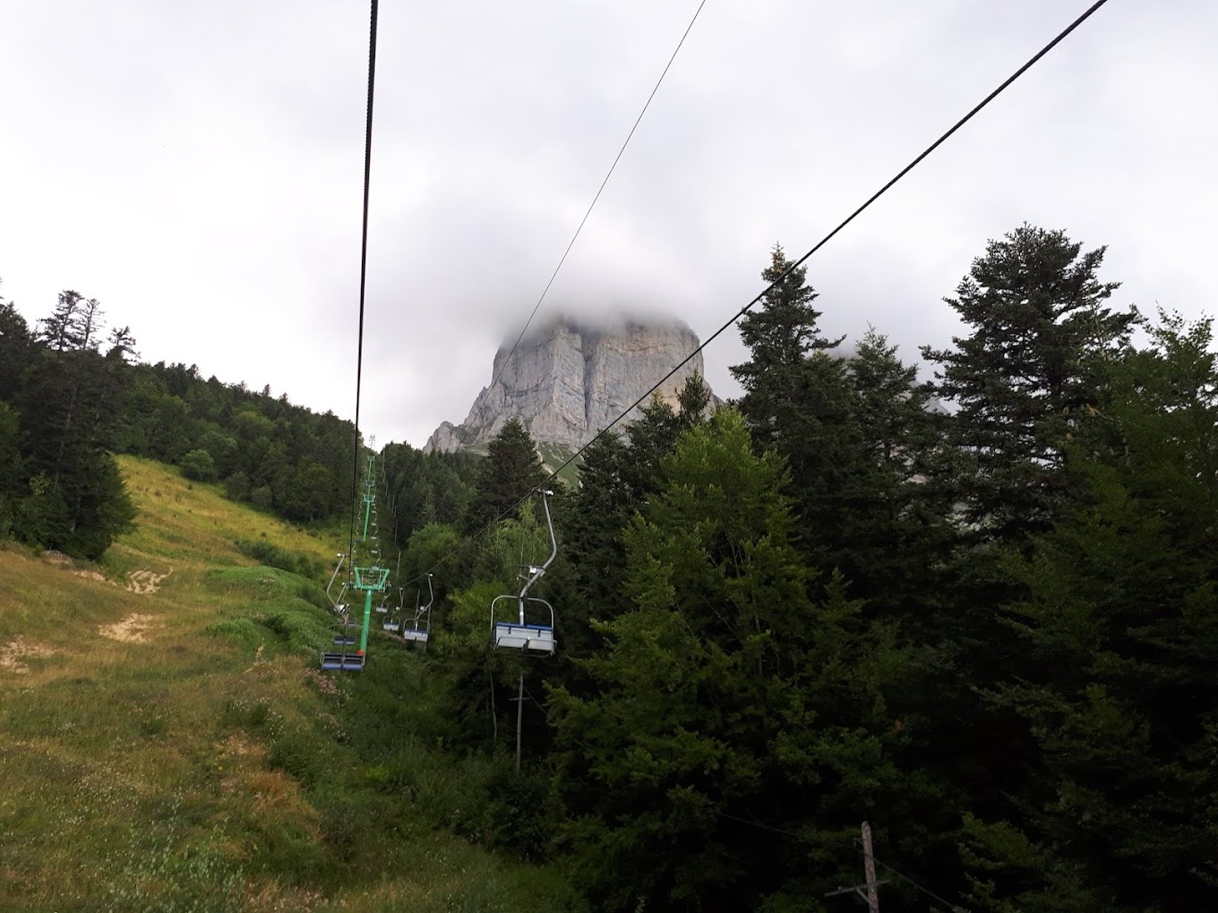 Col de l'Arzelier in France - a ski lift going up a hill with a mountain in the background.