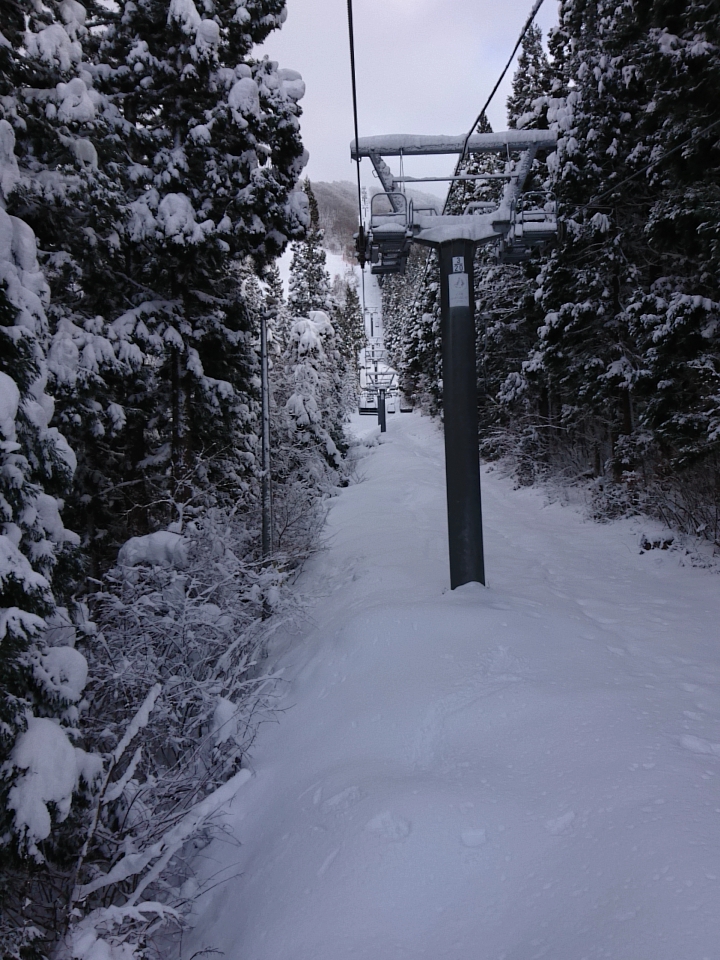Hanawa in Japan - a ski lift going up a snowy hill.