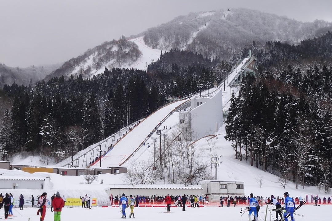 Hanawa in Japan - a group of people skiing down a snowy slope.