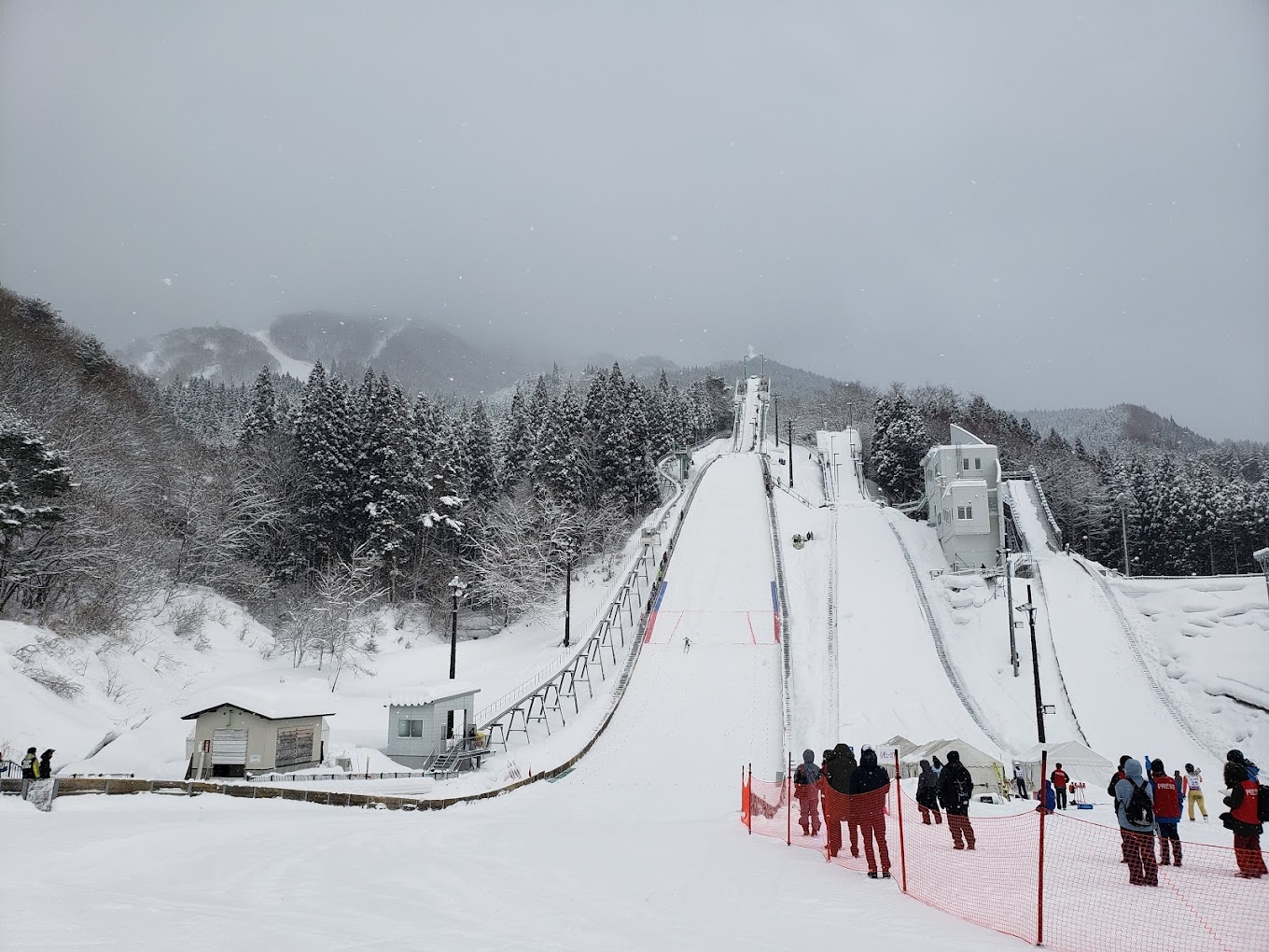 Hanawa in Japan - a group of people standing on top of a ski slope.