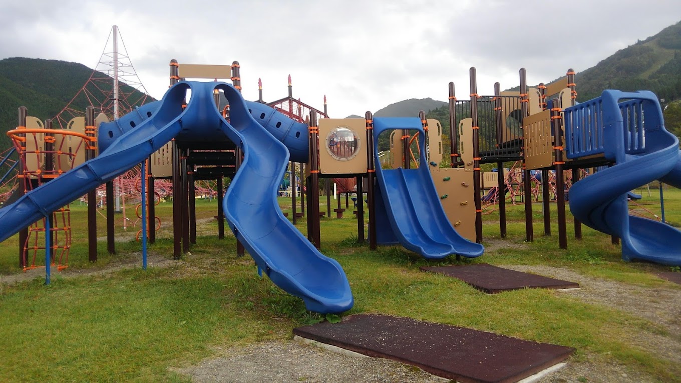 Hanawa in Japan - a playground with a blue slide and green grass.