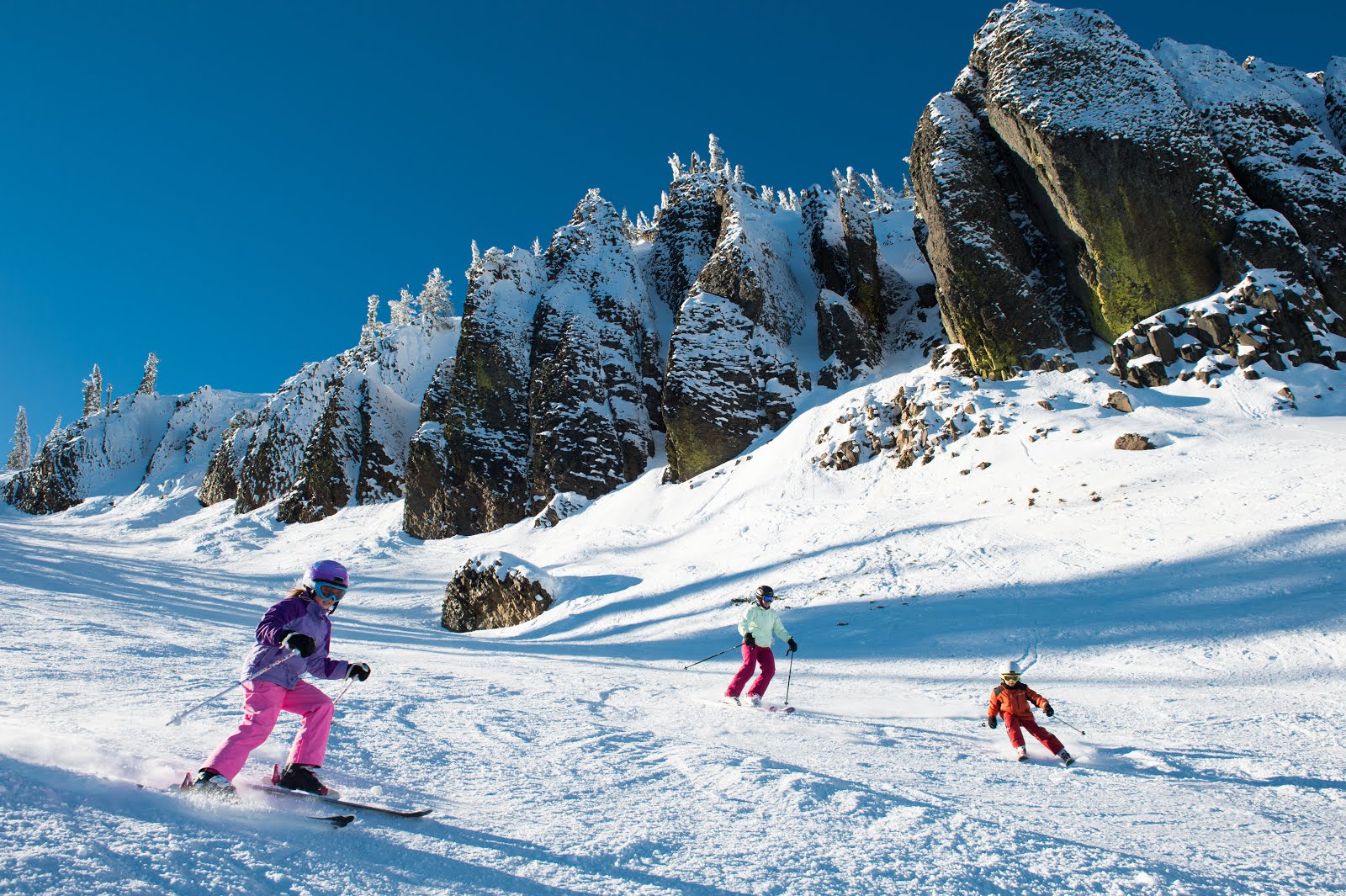 Mission Ridge in Canada - a group of people skiing down a snow covered mountain.