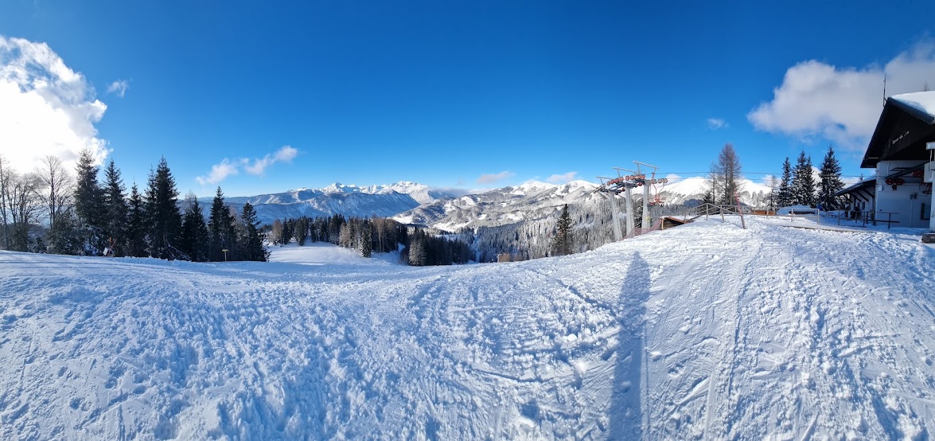 Španov vrh in Slovenia - a snow covered ski slope with trees in the background.