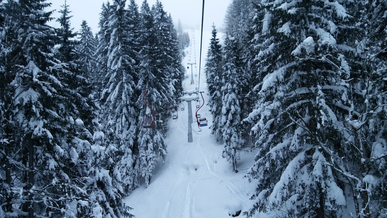 Španov vrh in Slovenia - a ski lift going through a snowy forest.