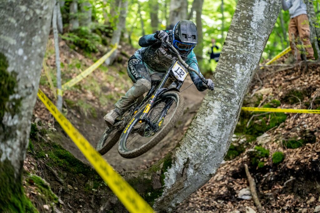 Seggiovia di Caldirola in Italy - a person riding a mountain bike through a forest.