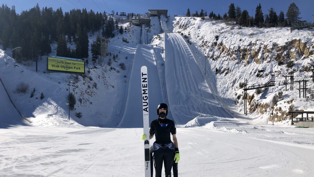 Utah Olympic Park in USA - a man standing in the snow holding a ski board.