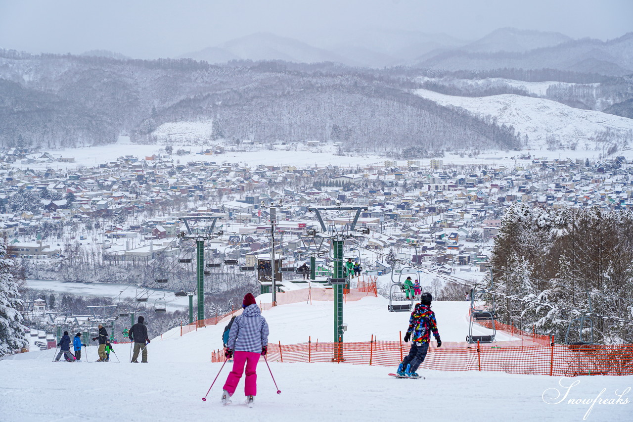 Kokusetsu Ashibetsu Ski Area in Japan - a group of people skiing down a hill.