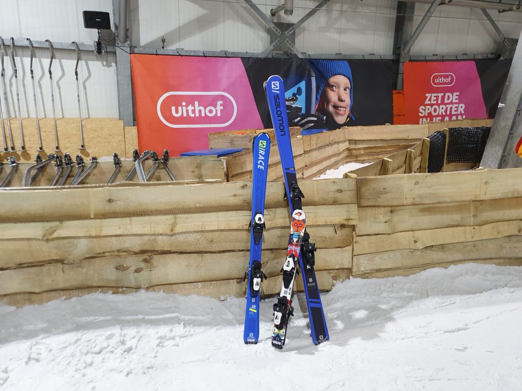 De Uithof in Netherlands - a snowboard and ski poles in the snow.
