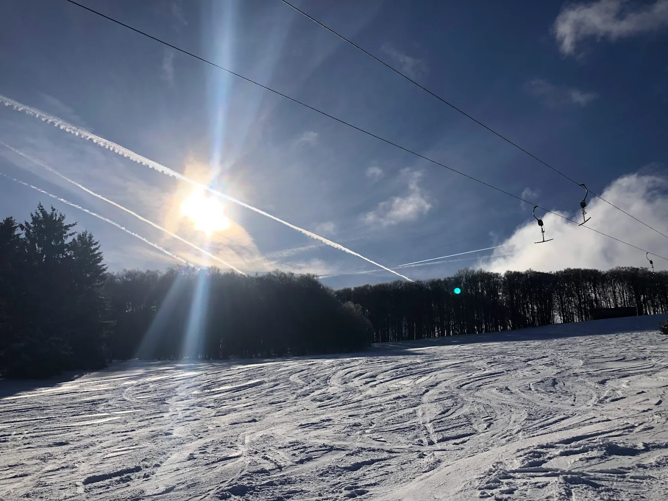Skilifte Kreuzberg in Germany - the sun is shining over a ski slope.