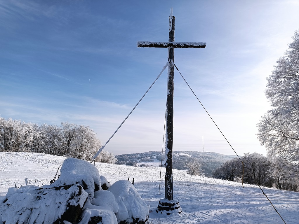 Skilifte Kreuzberg in Germany - a cross sitting on top of a snow covered hill.