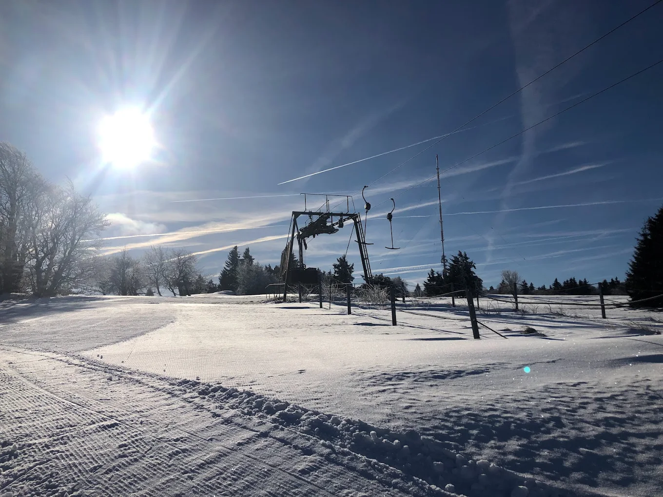 Skilifte Kreuzberg in Germany - the sun is shining over the snow covered ground.