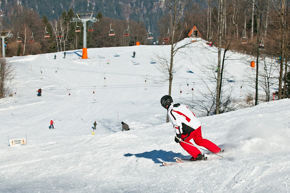 Gače in Slovenia - a man riding a snowboard down a snow covered slope.