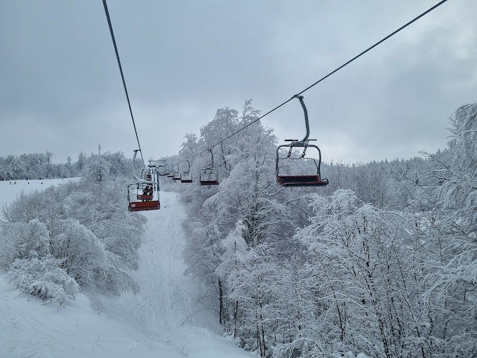 Gače in Slovenia - a ski lift going up a snowy mountain.