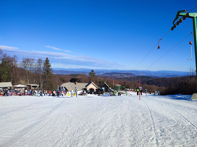 Gače in Slovenia - a ski slope with people skiing down it.
