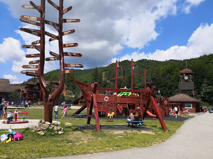 Valčianska Valley in Slovakia - a playground area with a sign post and children playing.