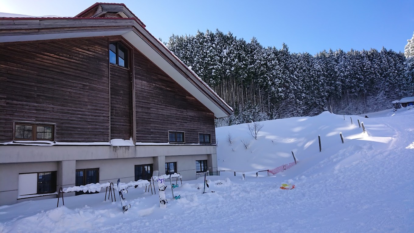 Kenmin-no-mori in Japan - a house covered in snow next to a forest.