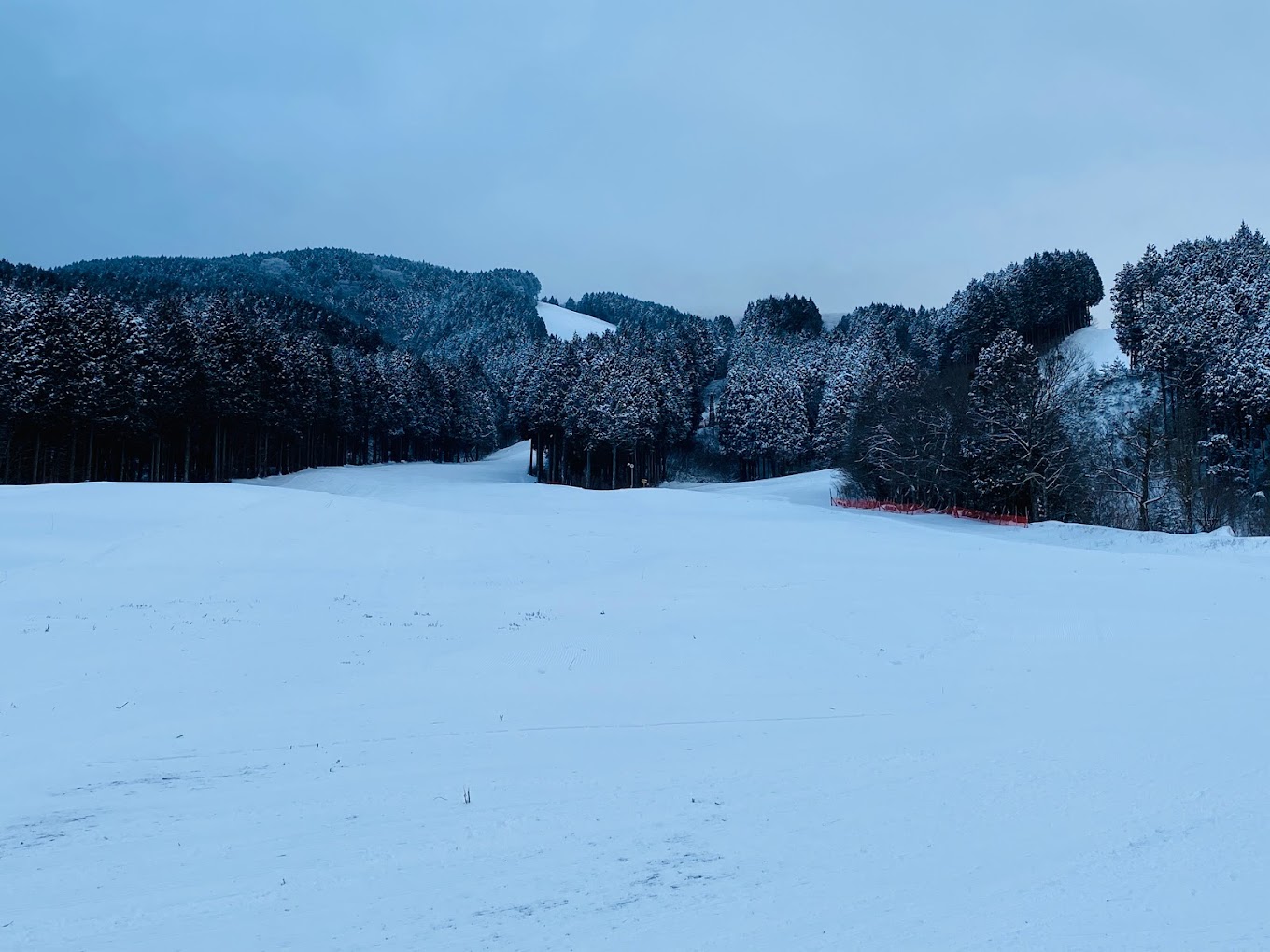 Kenmin-no-mori in Japan - a snow covered ski slope with trees in the background.