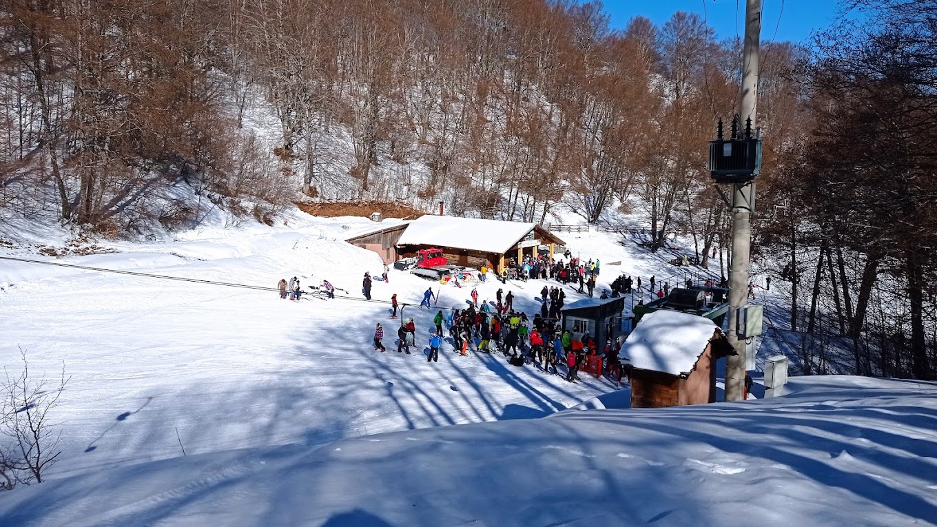 Monte Sirino -Conserva in Italy - a group of people skiing down a snowy slope.