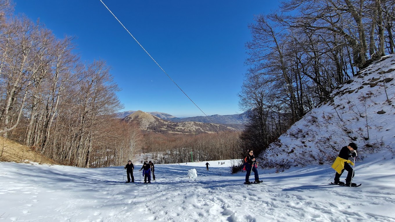 Monte Sirino -Conserva in Italy - a group of people skiing down a snow covered slope.