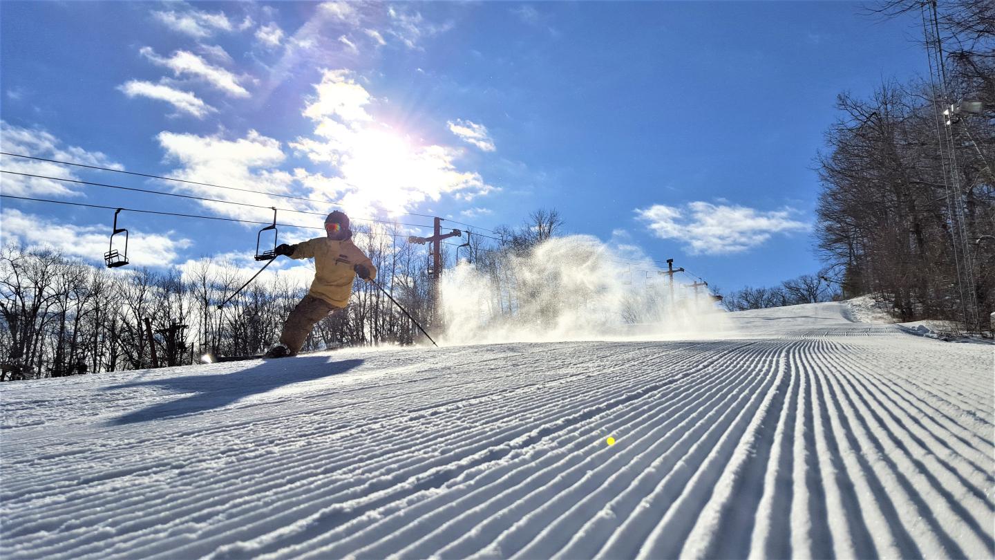 Nordic Mountain in USA - a person skiing down a hill on a sunny day.