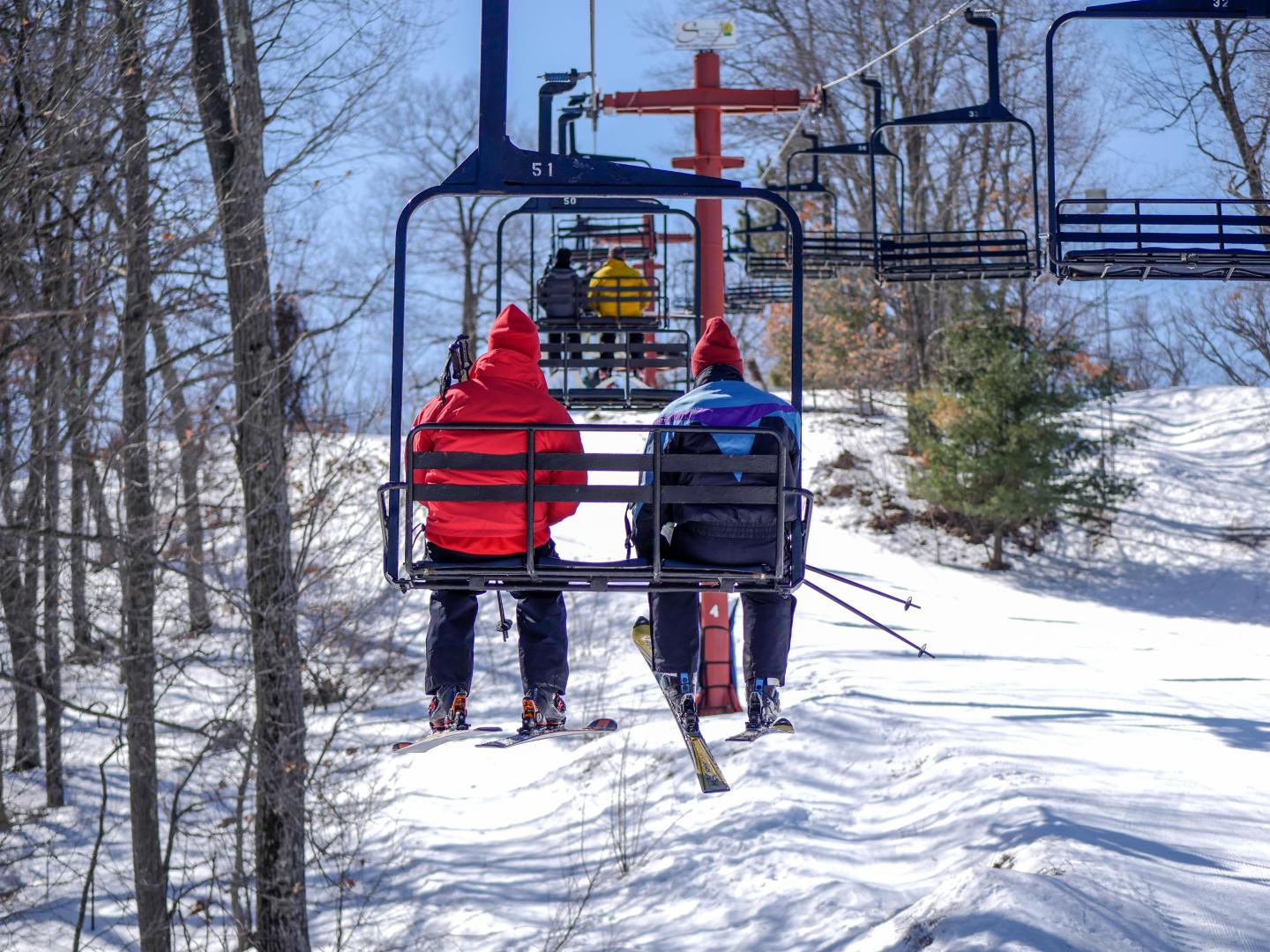 Nordic Mountain in USA - two people on a ski lift in the snow.