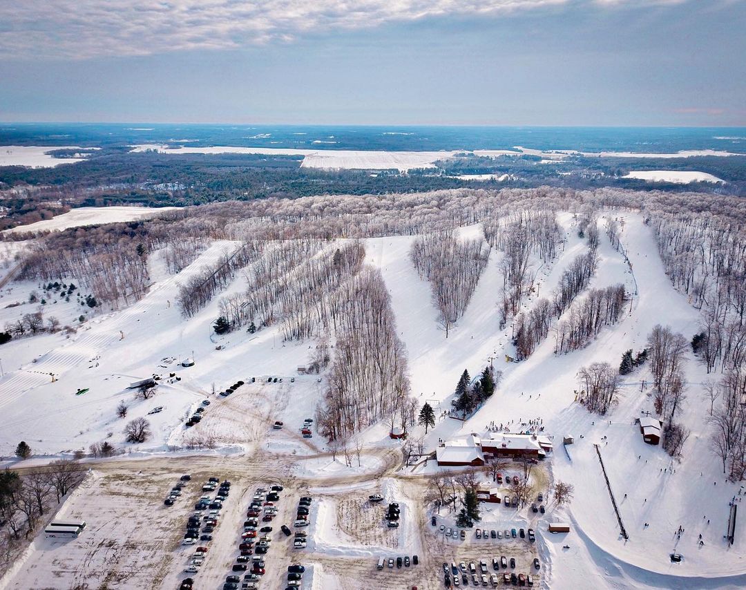 Ski resort at Nordic Mountain Wisconsin featuring a winter sports scene with a ski lift amidst stunning winter scenery.