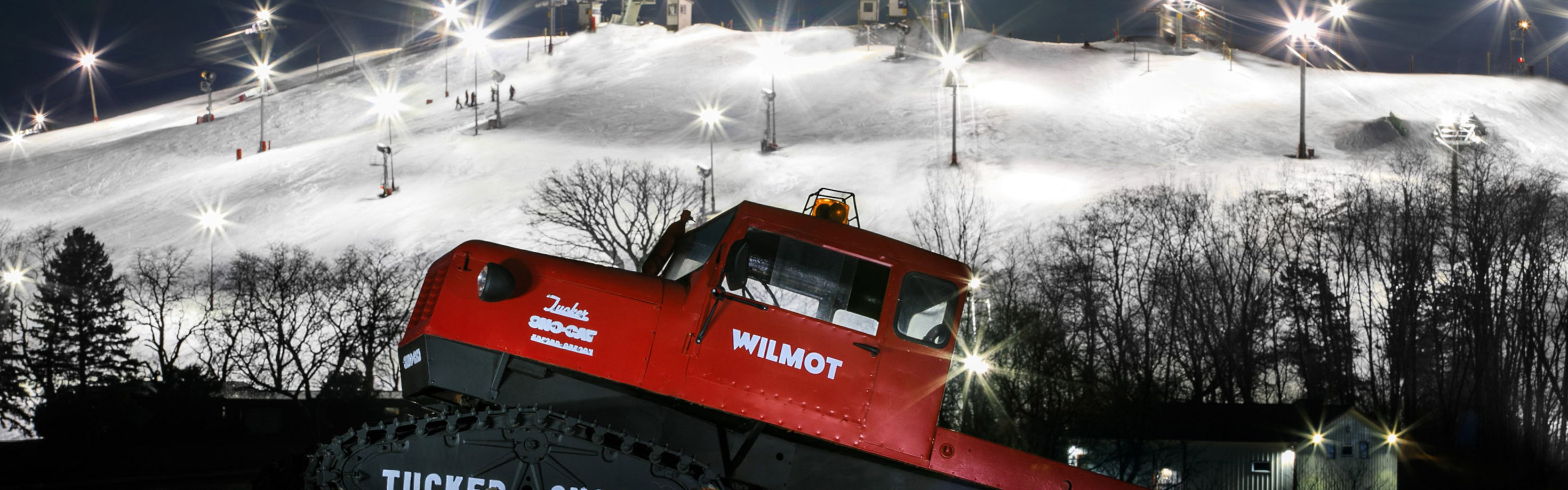 Wilmot Mountain in USA - a red train traveling down tracks next to a mountain.