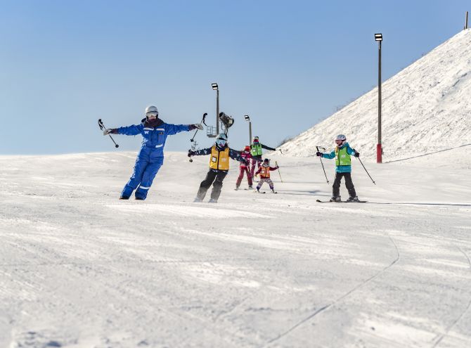 Wilmot Mountain in USA - a group of people skiing down a snow covered slope.