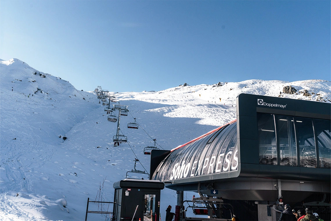 Cardrona in New Zealand - a ski lift going up a snowy mountain.