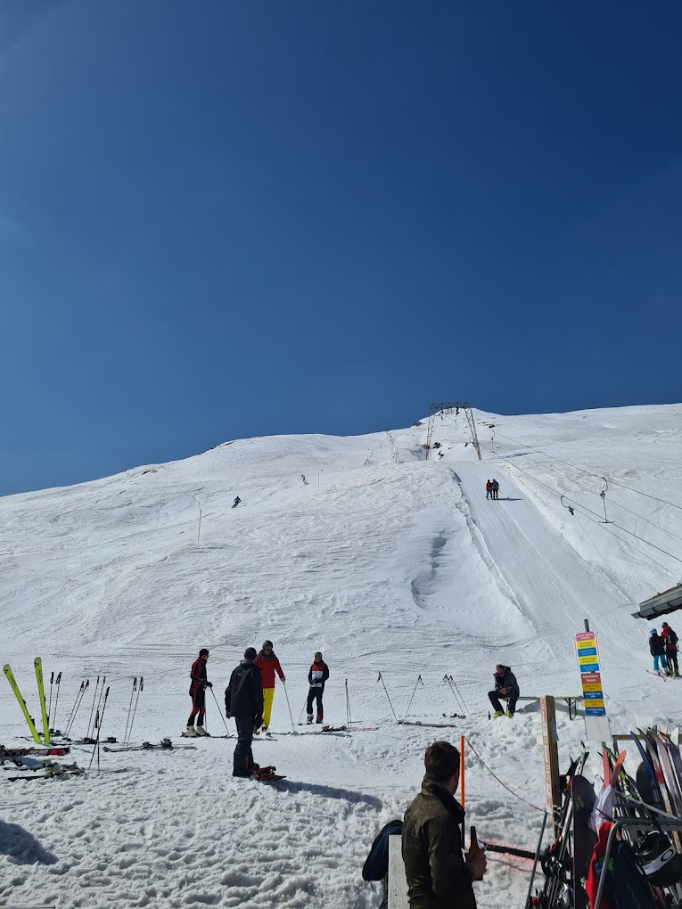 Avers in Switzerland - a group of people skiing down a snow covered mountain.