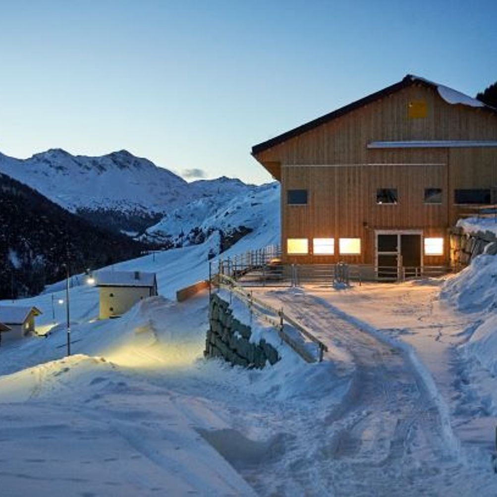 Avers in Switzerland - a wooden house in the middle of a snowy mountain.