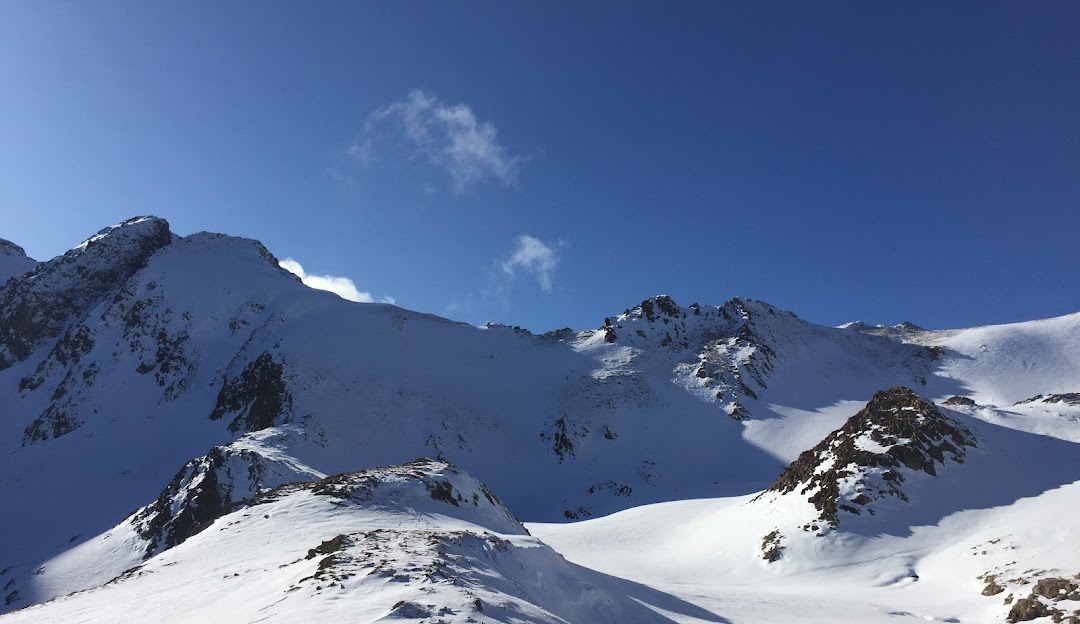 Pleta del Prat – Tavascan in Spain - a snow covered mountain with a blue sky.