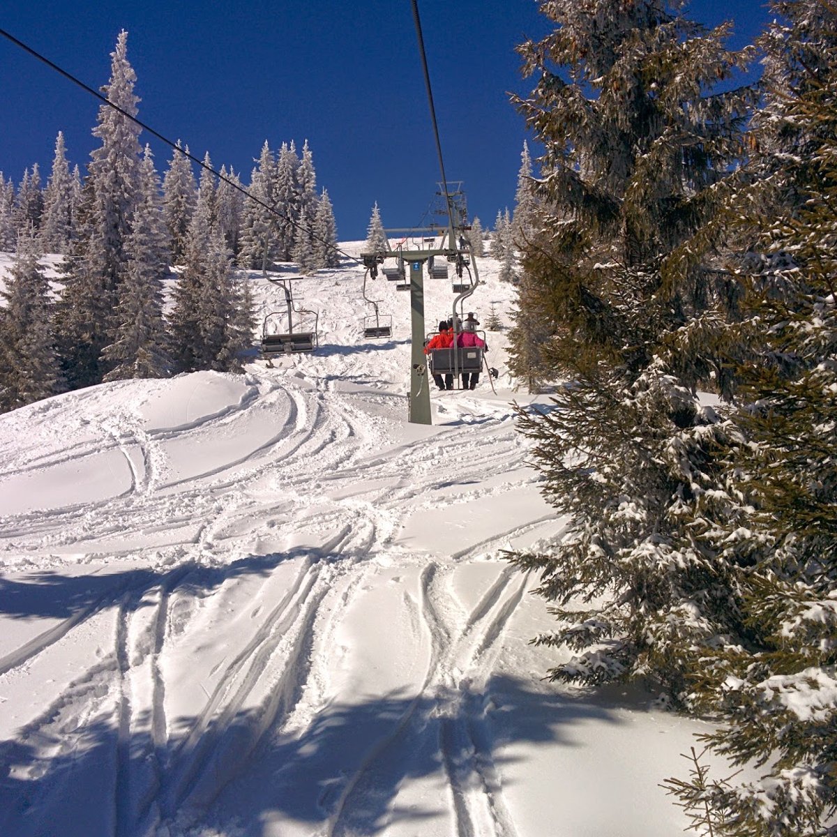Buscat Ski & Summer Resort in Romania - a person riding a ski lift in the snow.