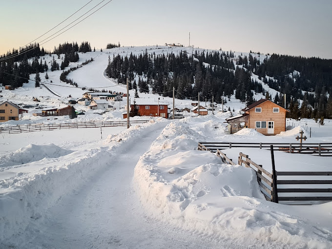 Buscat Ski & Summer Resort in Romania - a snow covered road leading to a small town.