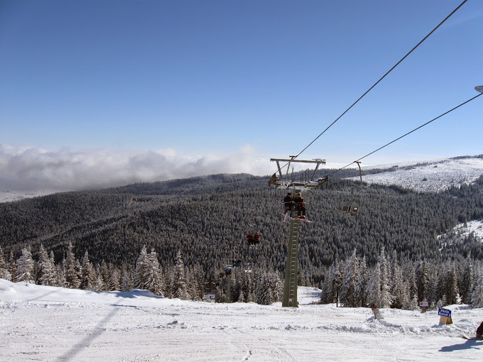 Buscat Ski & Summer Resort in Romania - a ski lift going up a snowy mountain.