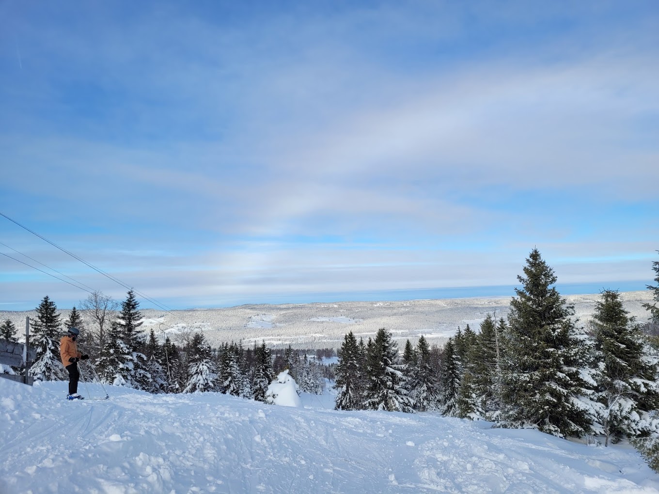 Lac de Joux in Switzerland - a person standing on top of a snow covered hill.